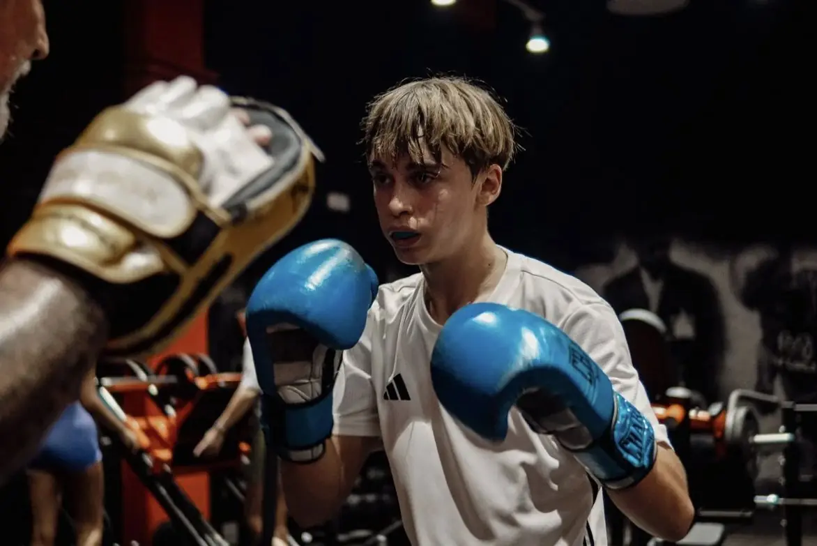 Boxeador junior entrenando con manoplas